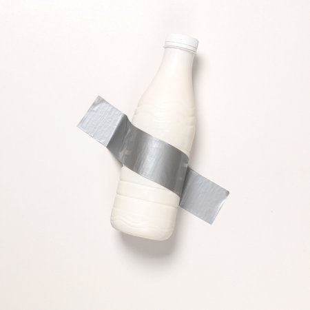 Milk bottle fixed with adhesive tape on white background. Conceptual pop, contemporary artの写真素材