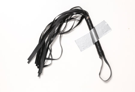Leather sex shop whip fixed with adhesive tape on a white background.の写真素材