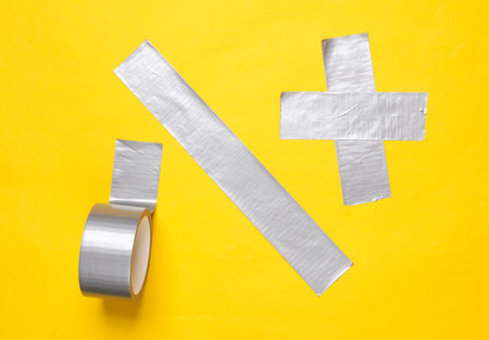 Different stripes of metallic adhesive tape on yellow backgroundの写真素材