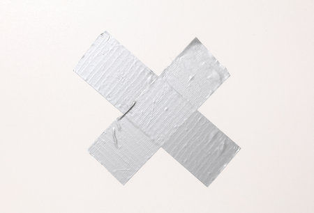 Cross stripes metallic adhesive tape on a white wallの写真素材