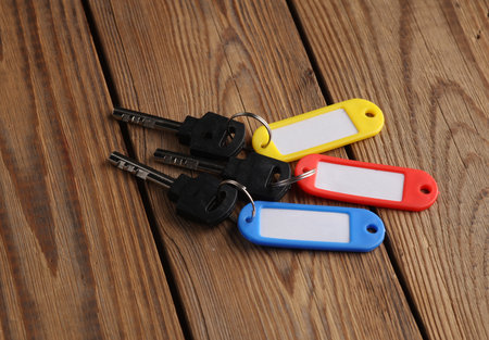 Plastic id tags with keys on wooden tableの写真素材