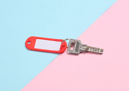 Plastic tag with key on pink blue backgroundの写真素材