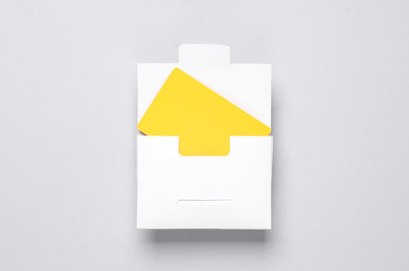 White packing box with yellow bank card on a gray background. Template for designの写真素材