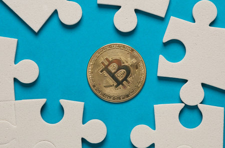 Jigsaw puzzle pieces and bitcoin on blue background.の写真素材