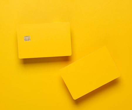 Mockup of yellow blank bank cards with chip on yellow background. Template for designの写真素材
