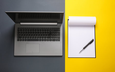 Clipboard and laptop on a yellow gray background. business concept. top view