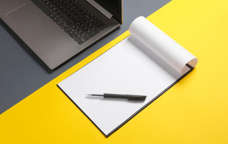 Clipboard and laptop on a yellow gray background. business concept.の写真素材
