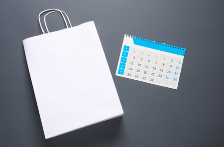 Seasonal sale. Shopping Bag With a calendar on a dark backgroundの写真素材