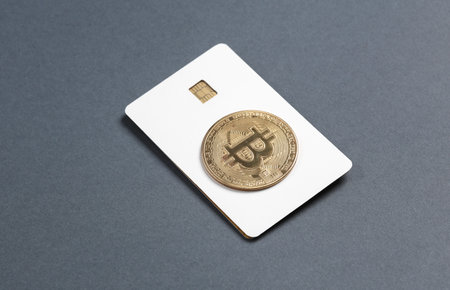 Mockup of white blank bank card with chip and bitcoin on dark background. template for design.