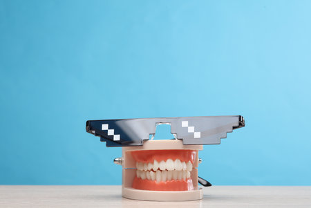 Human jaw model with pixel sunglasses on blue backgroundの写真素材