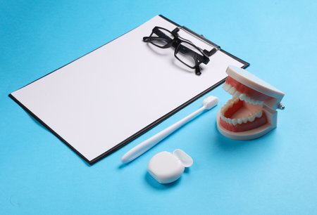 Caring for the oral cavity, a visit to the dentist. Clipboard with jaw, toothbrush and dental floss...