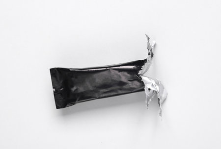 Empty open Black packaging of a chocolate or protein bar on gray backgroundの写真素材