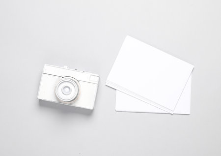 White camera with blank white photographs on gray background. Creative layout, mockup, template for designの写真素材