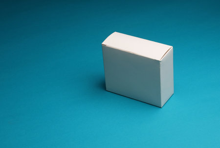 Empty white cardboard box on blue background