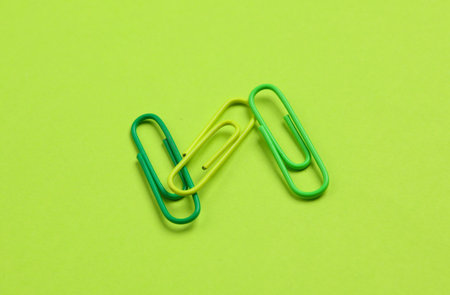 Pink paper clips on green backgroundの写真素材
