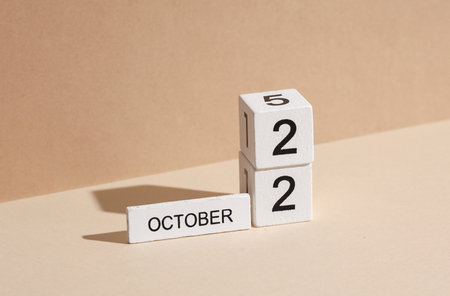 Wooden white block calendar with date october 22 on beige background with shadow. Creative layout, planning, holidaysの写真素材
