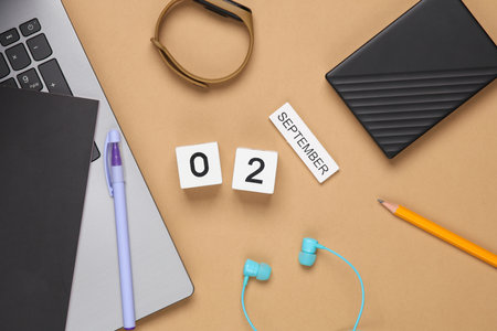 White wooden block calendar with date september 02 and modern gadgets, school or student accessories on beige background. top viewの写真素材