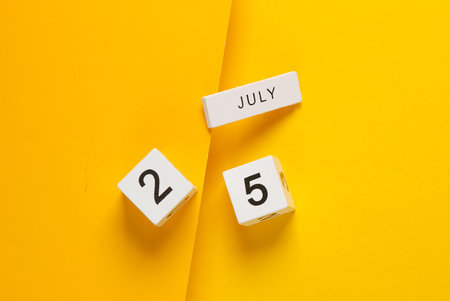 White calendar cubes with date july 25 on yellow background. creative layoutの写真素材