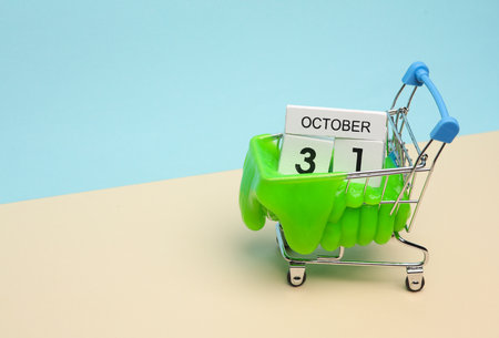 Minimalism halloween and shopping concept. Supermarket trolley with slime and 31 october calendar on pastel background. Trick or Treatの写真素材
