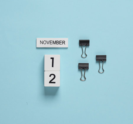 Business concept, planning, deadline. Block Calendar with date november 12 and binder clips on a...
