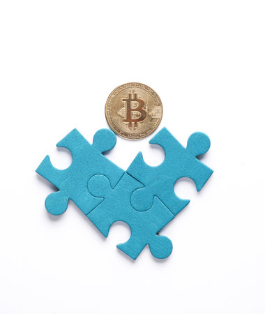 Blue jigsaw puzzle particles and bitcoin on white background. Business conceptの写真素材