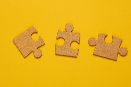 Golden jigsaw puzzle pieces on a yellow background. Business concept