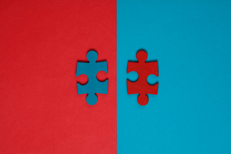 Blue and red jigsaw puzzle pieces on blue red background. Conceptual business photoの写真素材