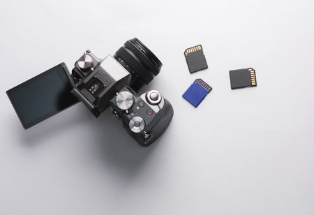 Modern digital camera with flip screen and three sd memory cards on gray backgroundの写真素材