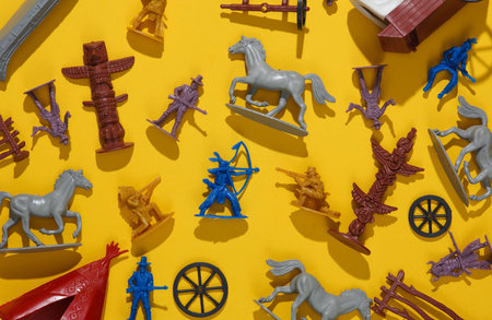 Set of soldiers and figurines from the theme of the wild west. Cowboys and American Indians. Creative layout, yellow backgroundの写真素材