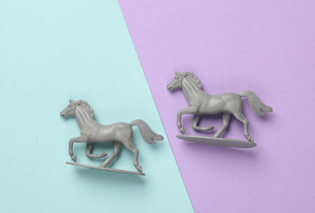 Plastic figurines of running horses on a pastel backgroundの写真素材