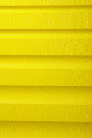 Plastic texture of yellow travel suitcase close-upの写真素材
