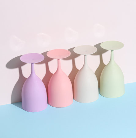 Creative layout with plastic colored glasses or goblets on a pastel background with a shadow. minimalism. Conceptual party conceptの写真素材