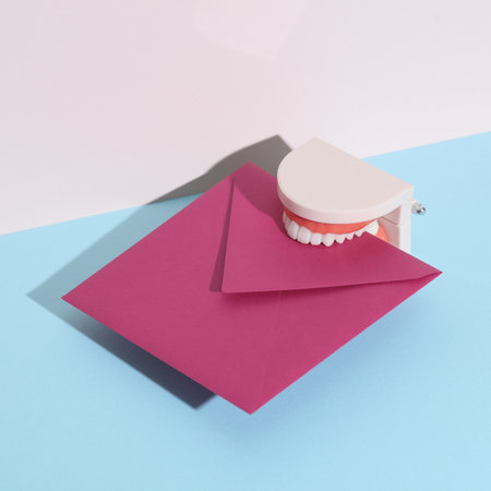 Jaw model with envelope on pastel background. Minimal, creative layoutの写真素材