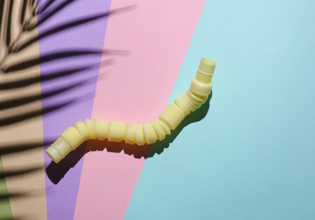 Pop tube on a pastel background with palm leaf shadow. Creative layout.の写真素材