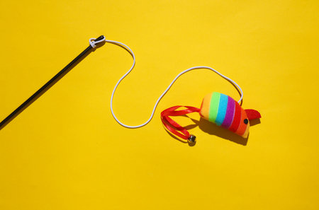 Toy mouse on a rope, yellow background. Cat toys for active gamesの写真素材