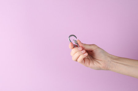 Metal carbine in a female hand on a purple background