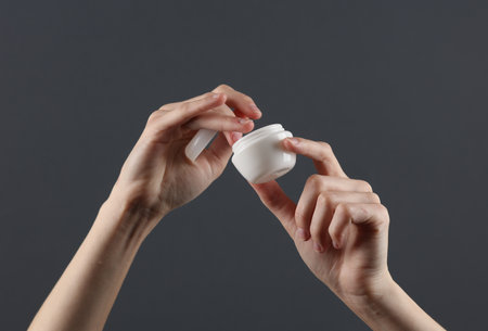 Homan applies cream from white tube to her hands. Template for design. Skin careの写真素材