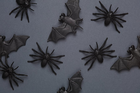 Plastic spiders and bats on a dark background. Halloween backgroundの写真素材