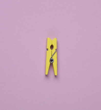 Yellow clothespin on a purple background. Minimal layoutの写真素材