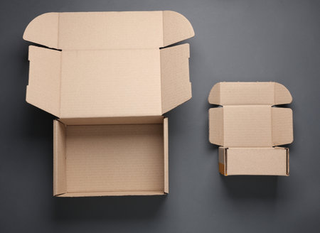 Opened cardboard parcel boxes on a dark background. Top viewの写真素材
