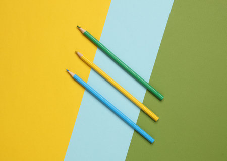 Three colored pencils on a colored background. Minimalismの写真素材