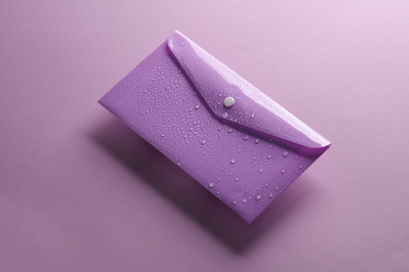 Plastic envelope with water drops on a purple background. Water protectionの写真素材