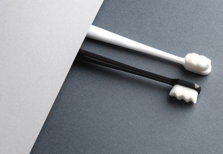Black and white toothbrushes on a gray backgroundの写真素材