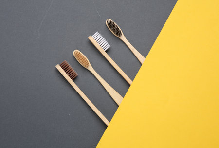 Eco bamboo toothbrushes on gray yellow background. Creative layout, Minimalismの写真素材