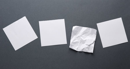 Blank and crumpled memo papers on dark gray backgroundの写真素材