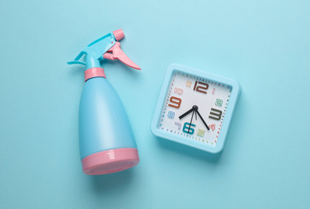 Spray bottle with clock on blue background