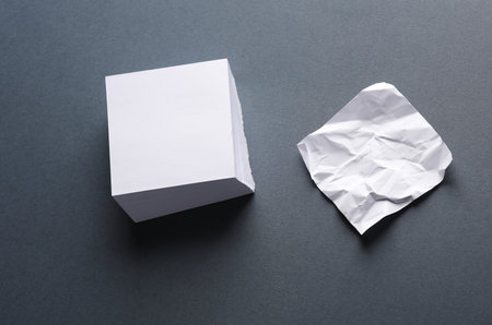 Blank and crumpled memo papers on dark gray backgroundの写真素材