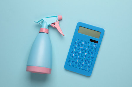 Spray bottle with calculator on blue backgroundの写真素材