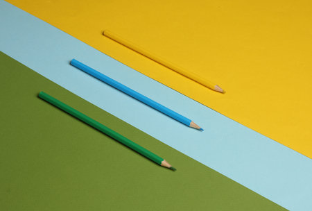 Three colored pencils on a colored background. Minimalismの写真素材
