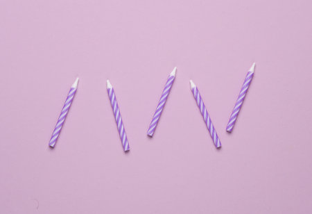 Purple birthday candles on pastel background. Minimalism party concept